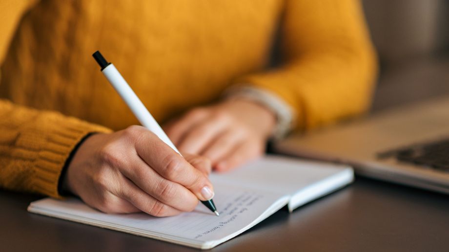 Une romancière est en train de rédiger le contenu de ses notes sur un ordinateur portable